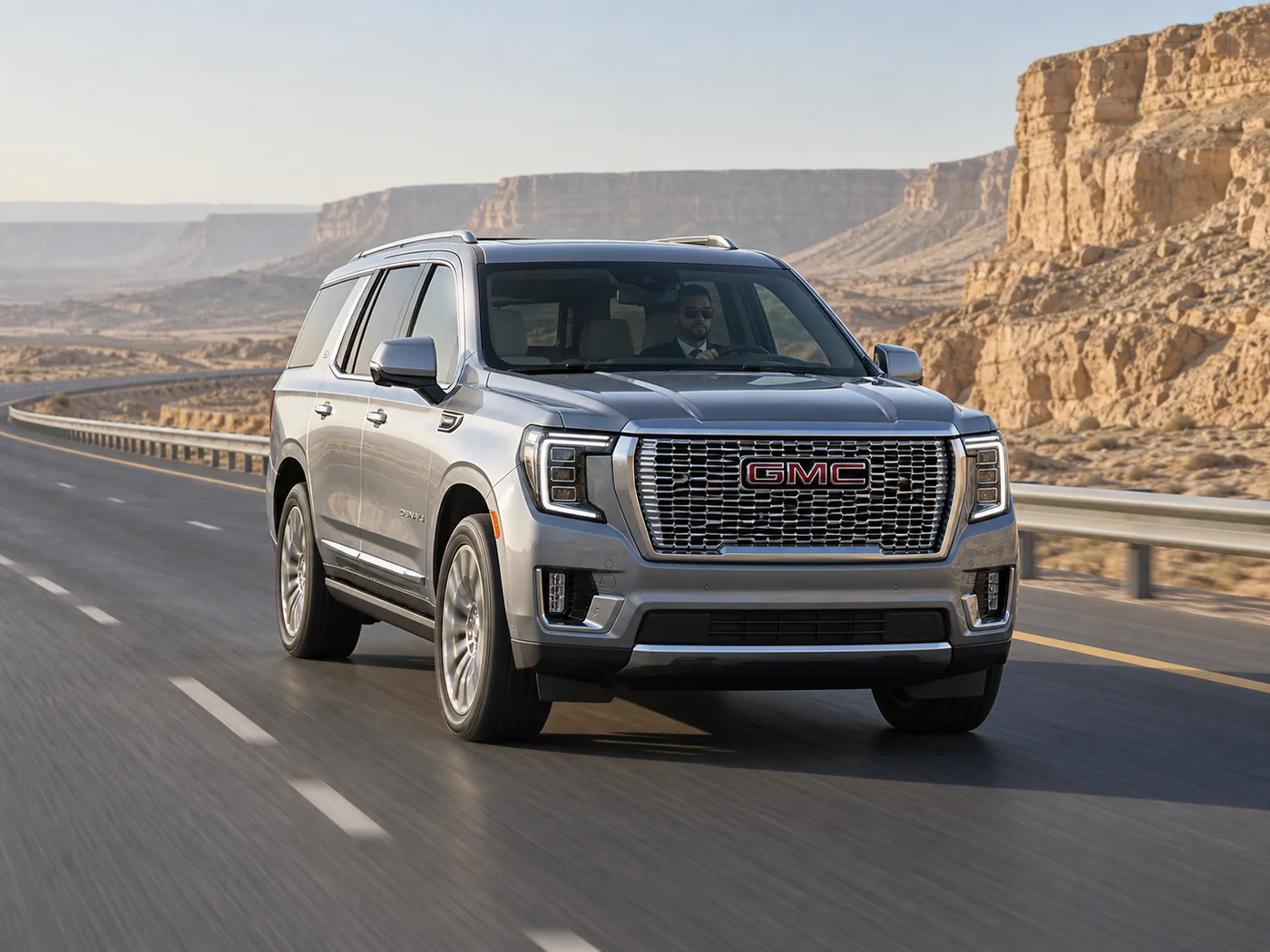 Silver GMC Yukon travelling along a desert highway beside limestone cliffs
